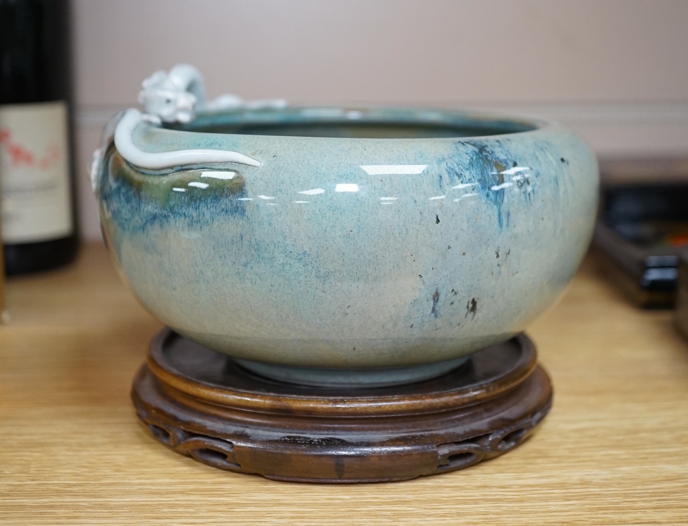 A Japanese Sumidagawa ware ‘dragon’ bowl, Meiji period, signed Ishiguro Koko, wood stand. Condition - scratching and crazing to the glaze on the interior otherwise good.